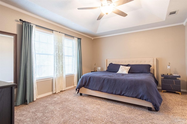 carpeted bedroom with a raised ceiling, ceiling fan, and multiple windows