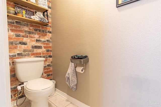 bathroom featuring tile patterned flooring, baseboards, and toilet