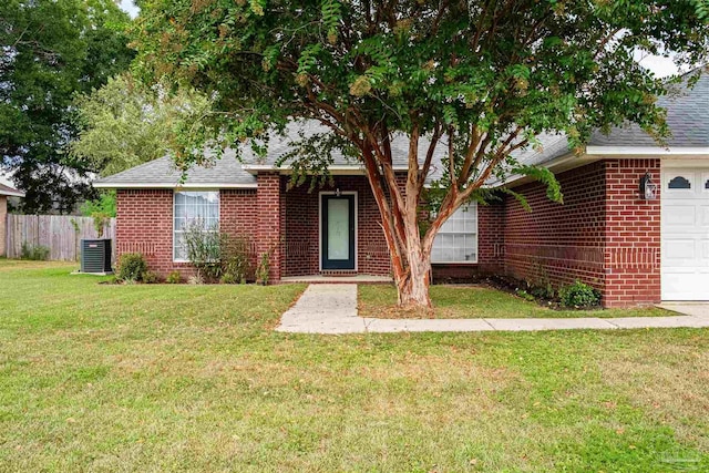 view of front of property with brick siding, roof with shingles, an attached garage, a front yard, and fence