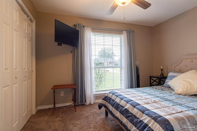 bedroom featuring a textured ceiling, a closet, baseboards, and carpet flooring