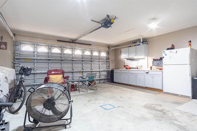 garage with a garage door opener and freestanding refrigerator