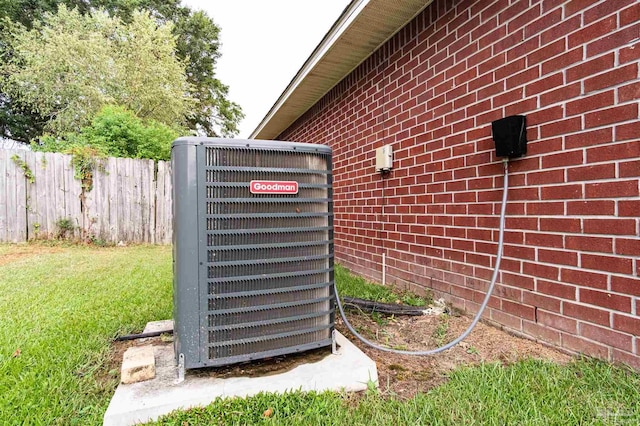 exterior details with brick siding, fence, and central AC unit