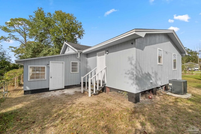 rear view of property featuring a yard and central air condition unit