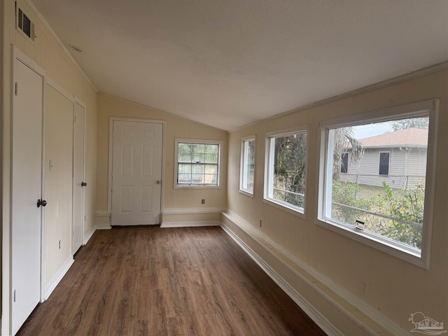 unfurnished bedroom with lofted ceiling, dark hardwood / wood-style flooring, and multiple windows