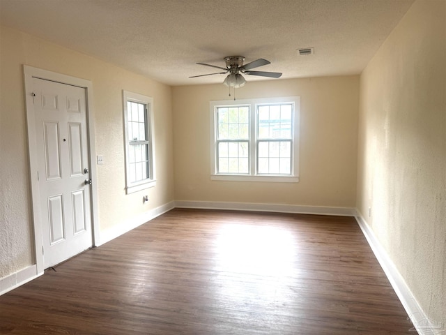 spare room featuring ceiling fan, dark wood-type flooring, and a textured ceiling