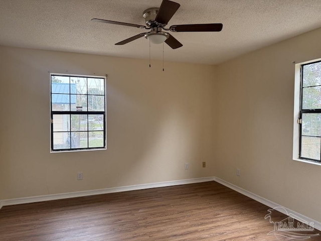 empty room with ceiling fan, hardwood / wood-style flooring, and a textured ceiling