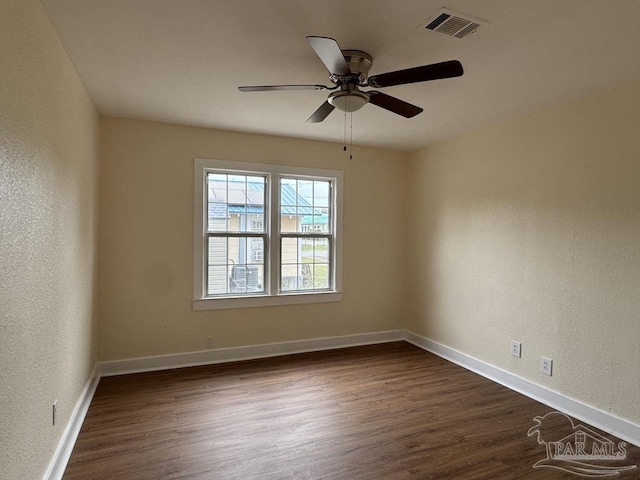 unfurnished room with ceiling fan and dark hardwood / wood-style flooring