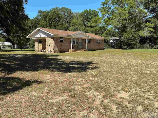5402 Douglas St, Milton, FL 32570 - ranch-style house with a front yard, brick siding, and covered porch