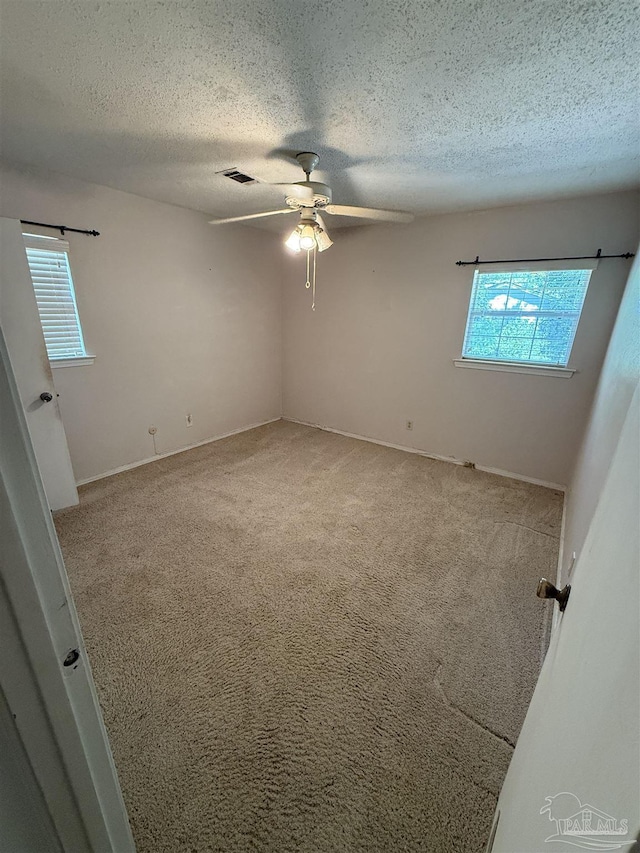 5402 Douglas St, Milton, FL 32570 - unfurnished room featuring a textured ceiling, a ceiling fan, carpet flooring, and baseboards