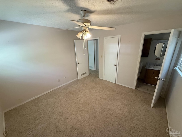 5402 Douglas St, Milton, FL 32570 - unfurnished bedroom featuring light colored carpet, baseboards, a sink, ensuite bath, and a textured ceiling