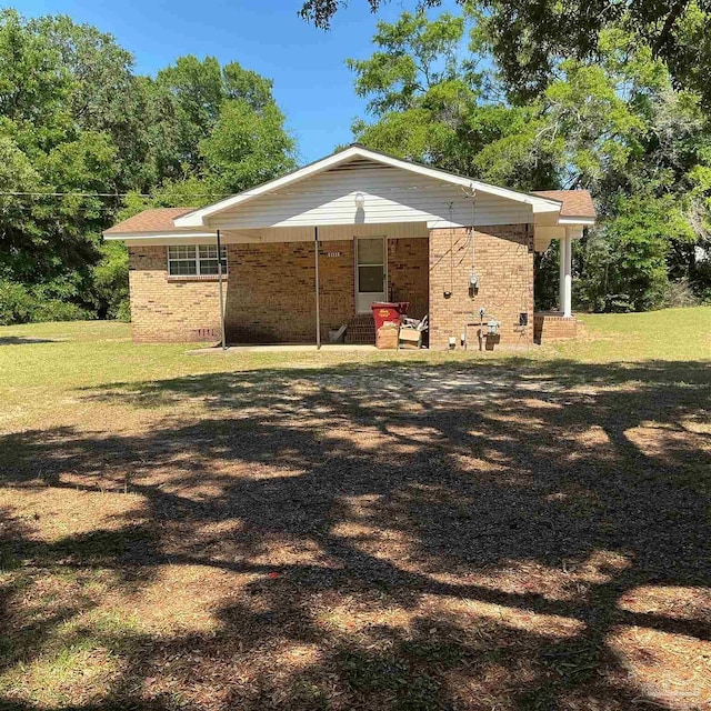 5402 Douglas St, Milton, FL 32570 - back of house featuring brick siding and a lawn