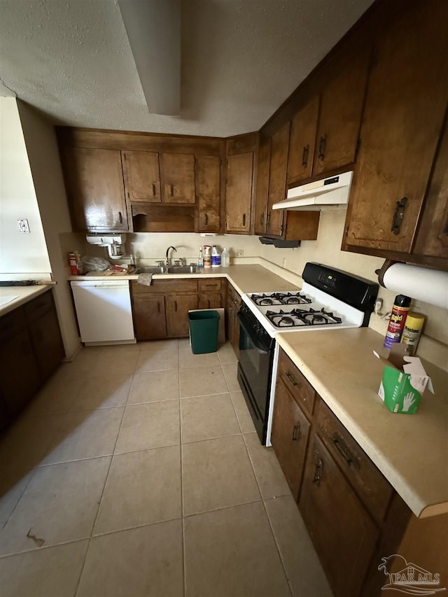 5402 Douglas St, Milton, FL 32570 - kitchen featuring black range with gas stovetop, under cabinet range hood, dishwasher, a sink, and light tile patterned flooring