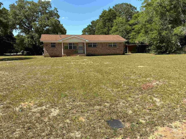 5402 Douglas St, Milton, FL 32570 - view of front facade with a front yard and brick siding