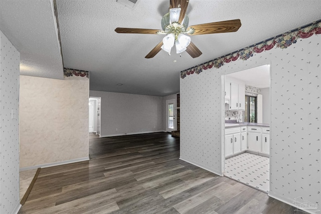 4831 E Olive Rd Unit 2A, Pensacola, FL 32514 - spare room with wallpapered walls, wood finished floors, a ceiling fan, a textured ceiling, and healthy amount of natural light