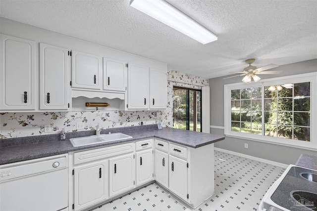 4831 E Olive Rd Unit 2A, Pensacola, FL 32514 - kitchen with white dishwasher, a sink, dark countertops, baseboards, and a textured ceiling