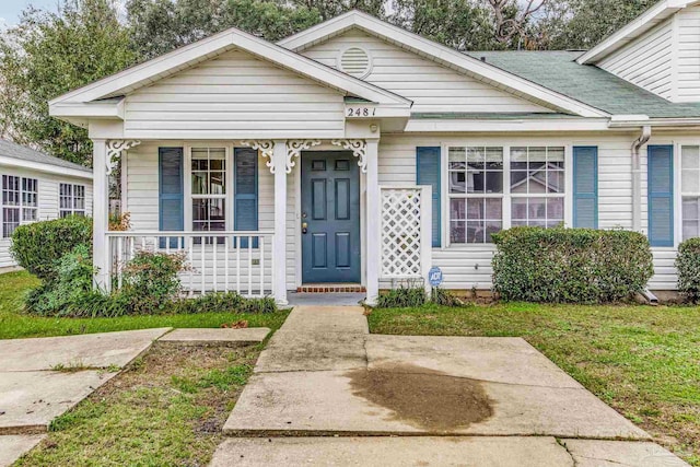 bungalow with a porch and a front lawn