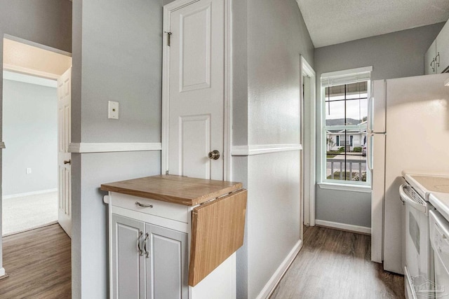 kitchen with hardwood / wood-style floors, white range oven, butcher block counters, and a textured ceiling