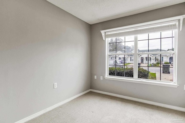 carpeted spare room featuring a textured ceiling