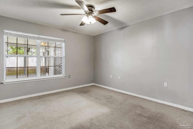 spare room featuring carpet flooring, ceiling fan, and a textured ceiling