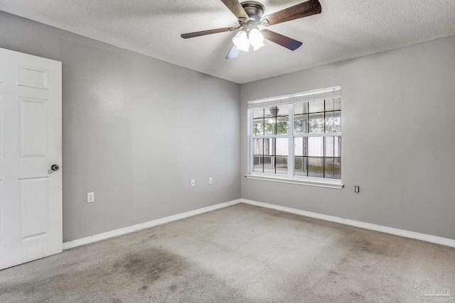 carpeted empty room featuring ceiling fan and a textured ceiling