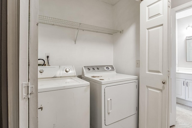 laundry area featuring light tile patterned floors and washing machine and clothes dryer