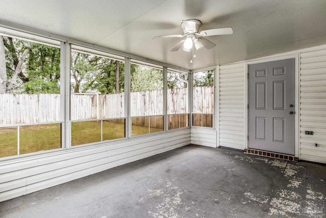 unfurnished sunroom featuring ceiling fan