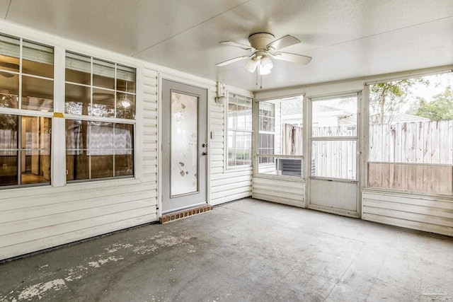 unfurnished sunroom featuring ceiling fan