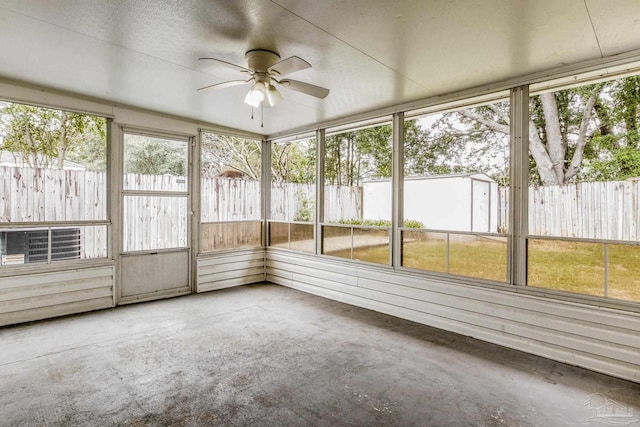 unfurnished sunroom featuring ceiling fan