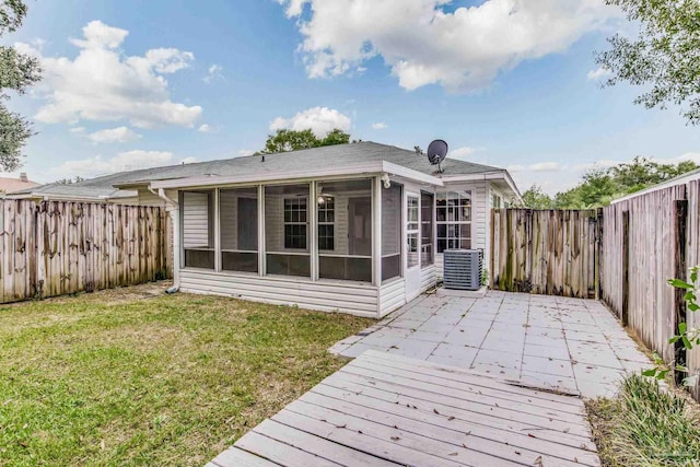 back of house featuring a lawn, a sunroom, and central AC