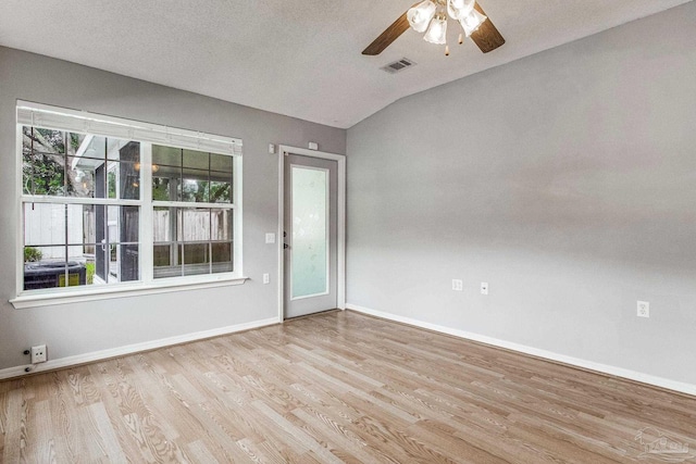 unfurnished room featuring a textured ceiling, ceiling fan, light hardwood / wood-style floors, and vaulted ceiling