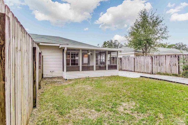 back of property featuring a sunroom and a yard