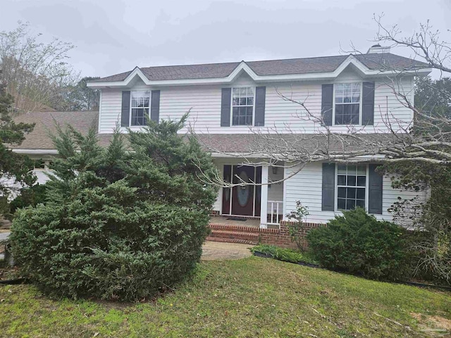 traditional-style house featuring a front yard