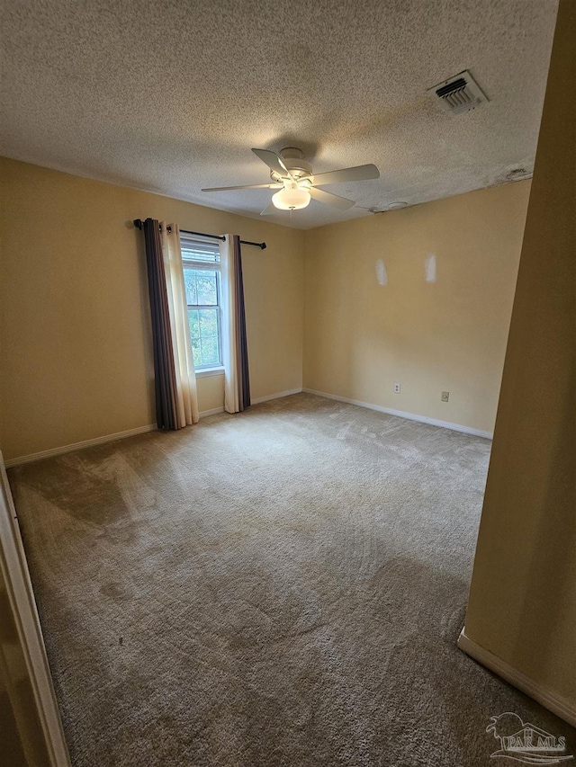 unfurnished room with baseboards, visible vents, carpet floors, and ceiling fan