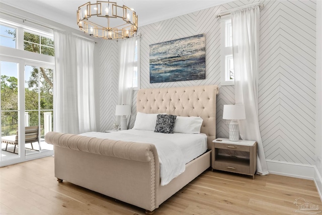 bedroom with access to exterior, multiple windows, and light wood-type flooring