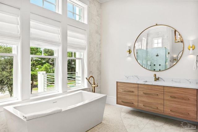 bathroom with marble finish floor, a freestanding tub, a shower stall, and vanity