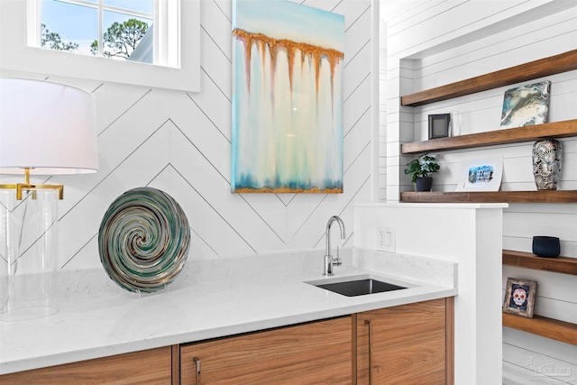 interior space featuring light stone counters and sink