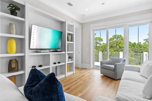 living room featuring built in features, a wealth of natural light, visible vents, and wood finished floors