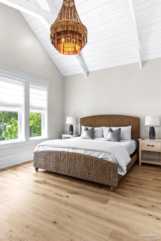 bedroom with wood ceiling, a notable chandelier, light hardwood / wood-style flooring, and vaulted ceiling with beams