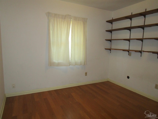 spare room featuring wood finished floors and baseboards