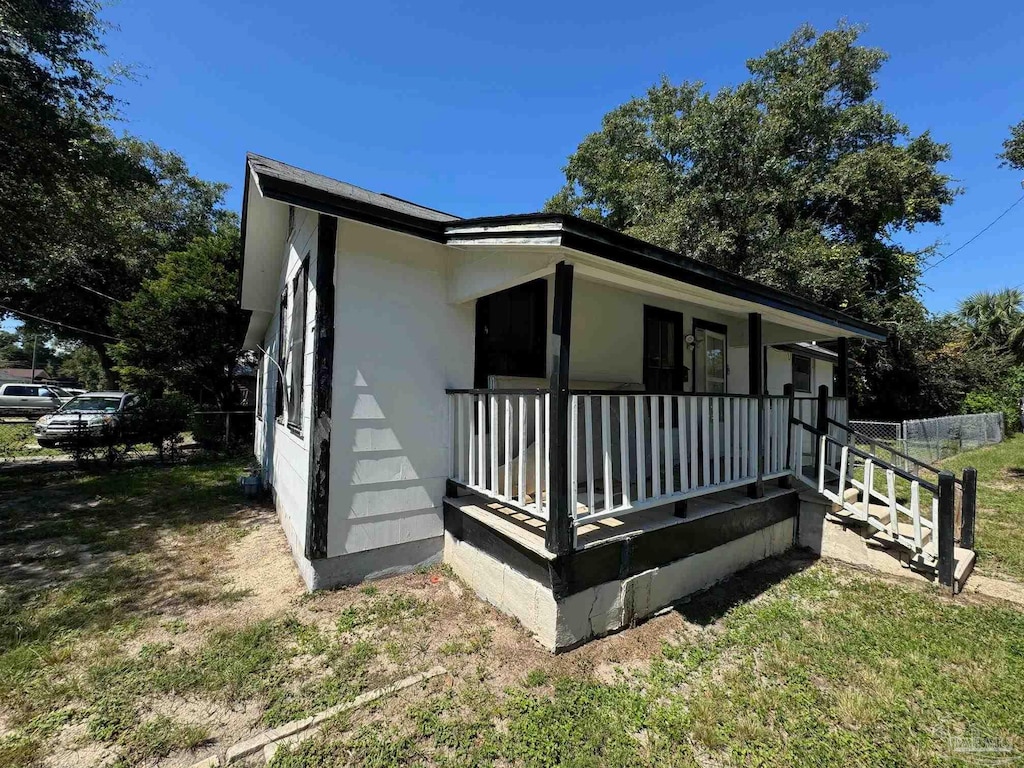 exterior space with covered porch and a yard