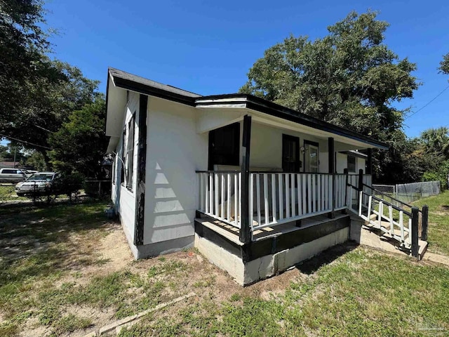 exterior space with covered porch and a yard