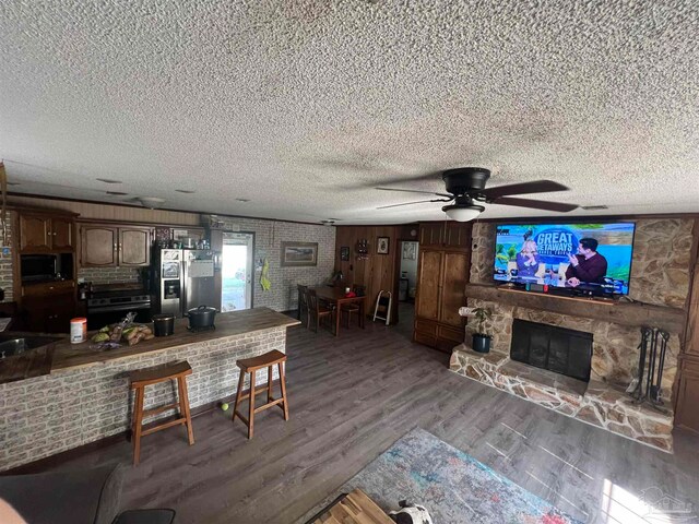 kitchen featuring dark brown cabinets, a textured ceiling, appliances with stainless steel finishes, and dark hardwood / wood-style flooring