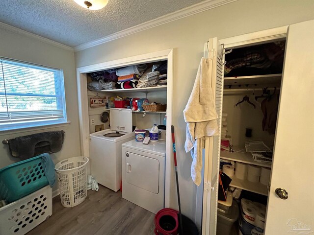 washroom featuring a textured ceiling, crown molding, hardwood / wood-style floors, and washing machine and clothes dryer