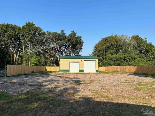 view of yard with a garage and an outbuilding