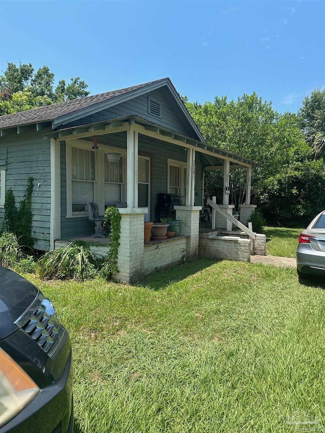 view of property exterior featuring a yard and covered porch