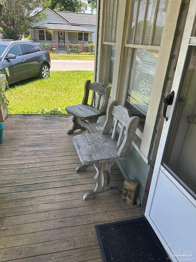 deck with a lawn and a porch