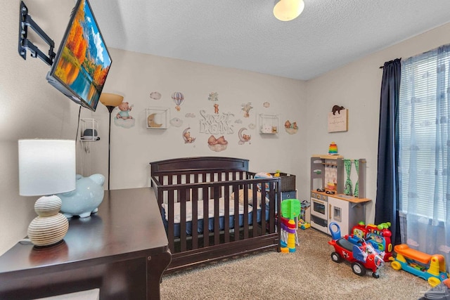 carpeted bedroom featuring a nursery area and a textured ceiling