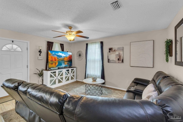 living room featuring ceiling fan and a textured ceiling