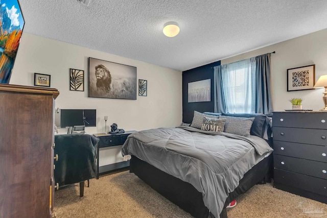 bedroom with light colored carpet and a textured ceiling