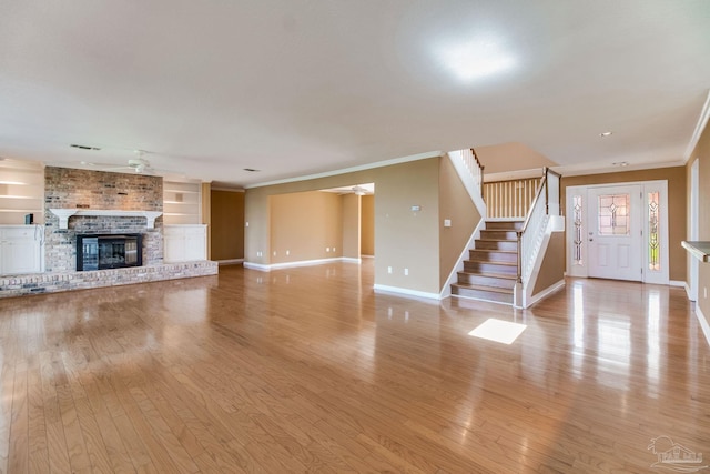unfurnished living room featuring crown molding, light wood-style flooring, and baseboards